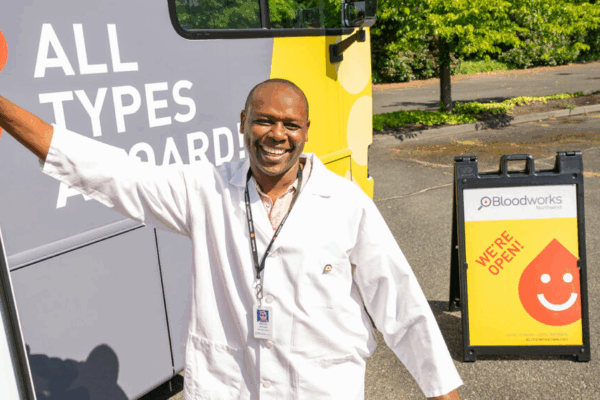 A blood collection specialist welcomes you onto our newest bloodmobile